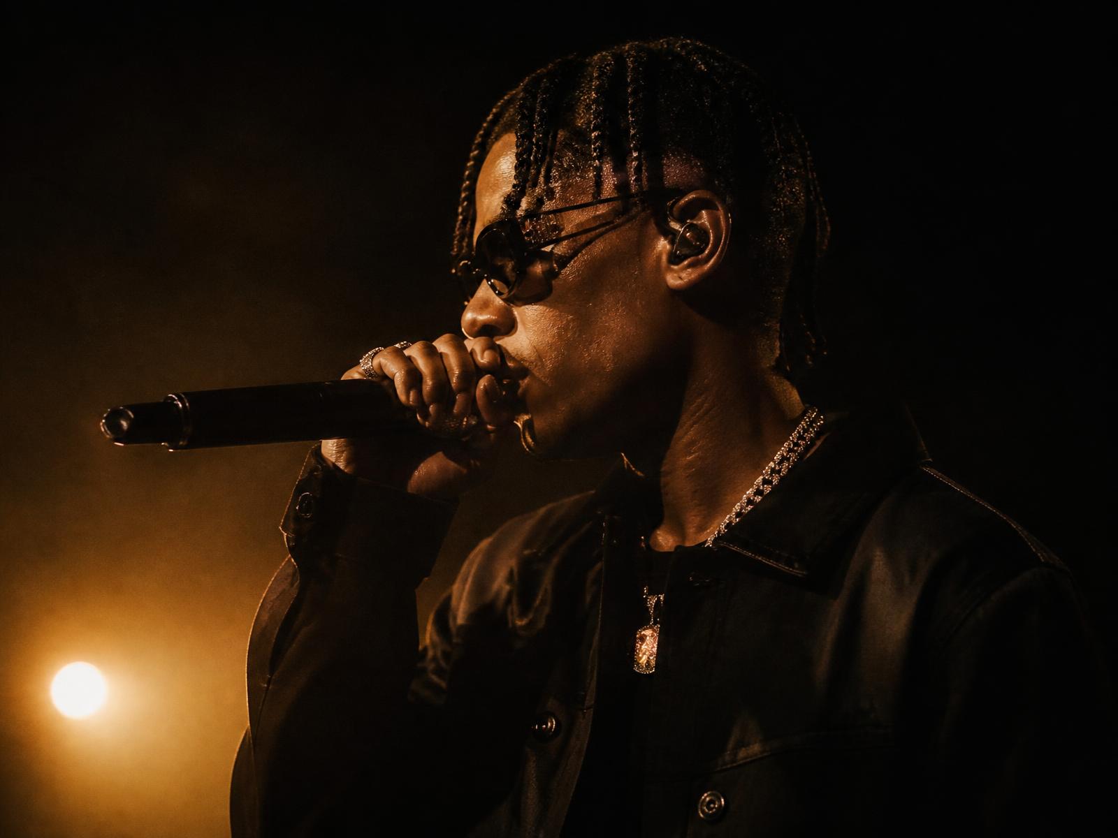 Independent African artist performing live on a dark stage